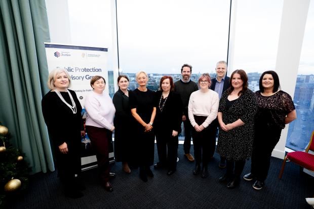 Probation Board and Probation Service staff with Dr Brian Payne standing in front of a window 